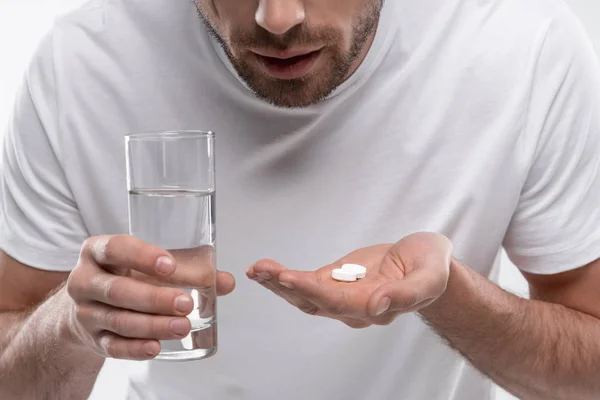 Uomo con pillole e bicchiere d'acqua — Foto stock