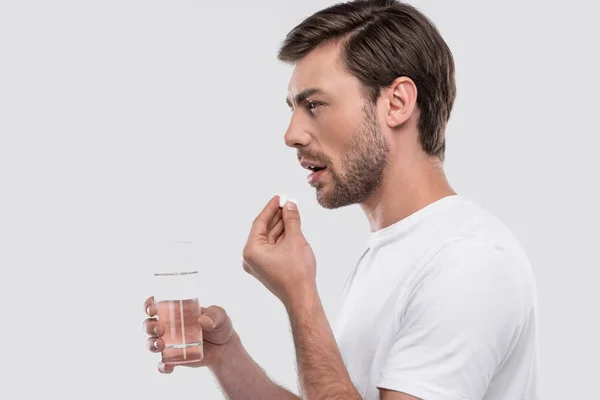 Hombre con medicamentos y vaso de agua - foto de stock