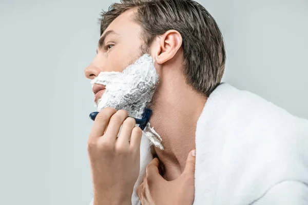 Man in foam shaving with razor — Stock Photo