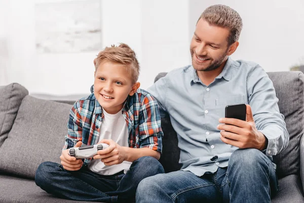 Garçon jouer à des jeux vidéo avec papa — Photo de stock