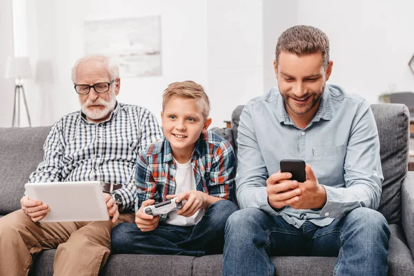 Famiglia sul divano con dispositivi — Foto stock