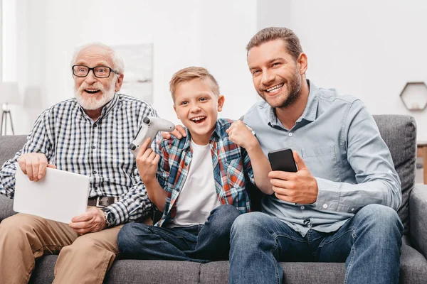 Familia animando por chico jugando videojuegos - foto de stock