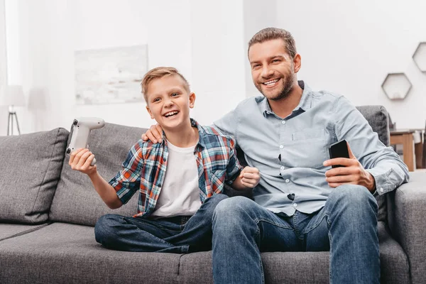 Père et fils jouant aux jeux vidéo — Photo de stock