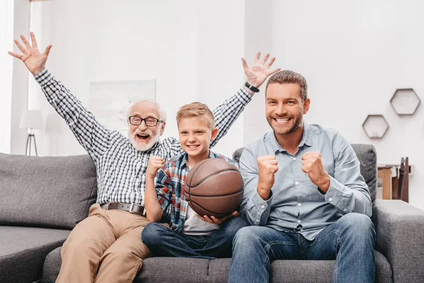 Animando a la familia viendo baloncesto en casa - foto de stock