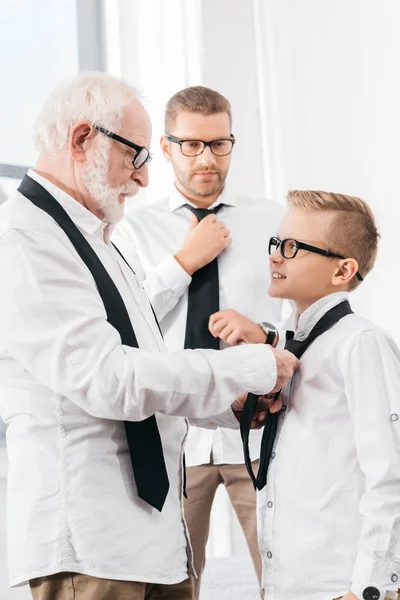 Grandfather helping grandson with necktie — Stock Photo