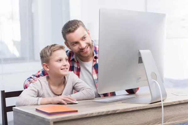Отец и сын с настольным компьютером — стоковое фото