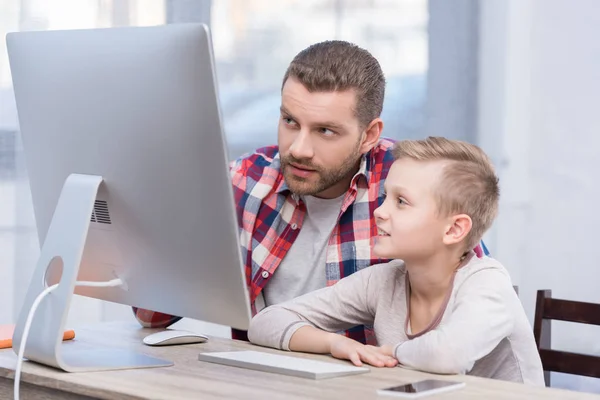 Padre e hijo con computadora de escritorio - foto de stock