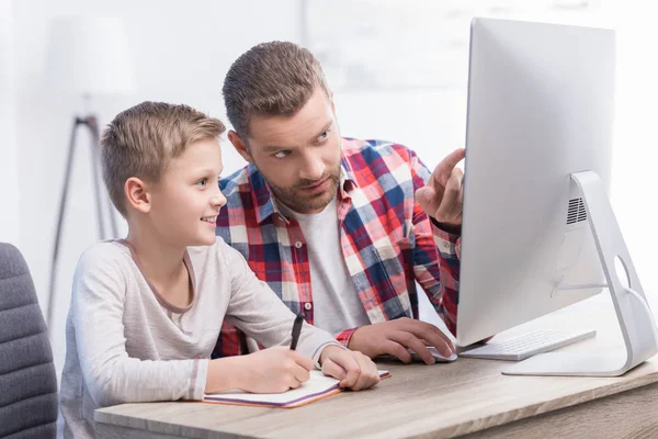 Отец и сын с настольным компьютером — стоковое фото