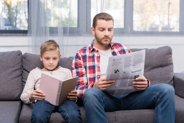 Pai e filho lendo em casa — Fotografia de Stock