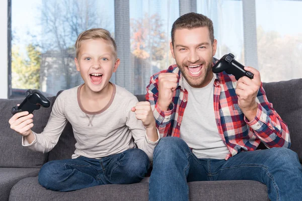 Padre e figlio giocano con i joystick — Foto stock