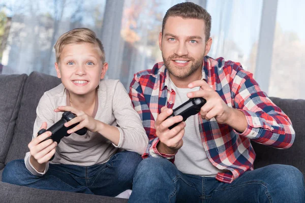 Père et fils jouant avec des joysticks — Photo de stock