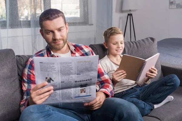 Pai e filho lendo em casa — Fotografia de Stock