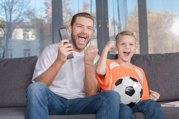Father and son watching soccer match — Stock Photo