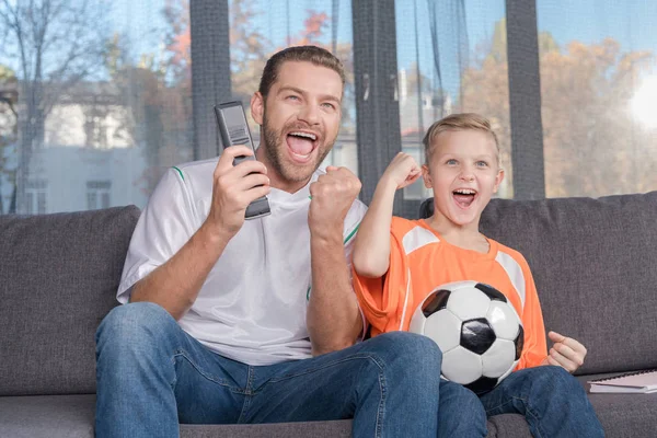 Padre e hijo viendo partido de fútbol - foto de stock