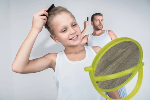 Padre e hijo peinando el cabello - foto de stock