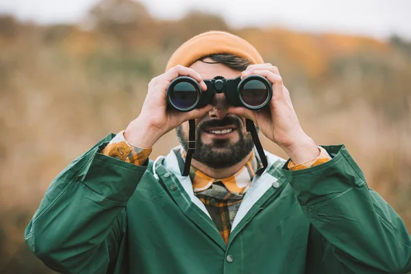 Mann blickt durch Fernglas — Stockfoto