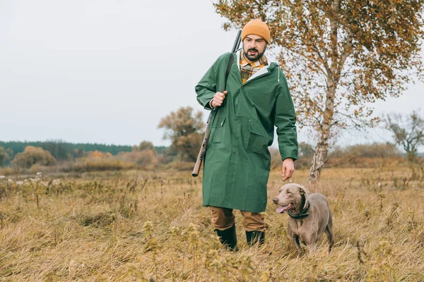 Mann geht mit Hund und Waffe spazieren — Stockfoto