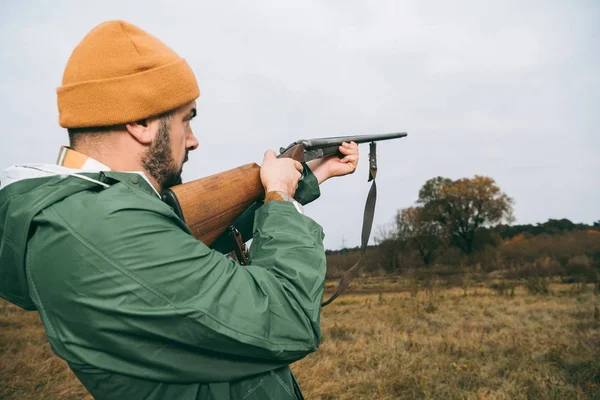 Caçador apontando para algo com arma — Fotografia de Stock