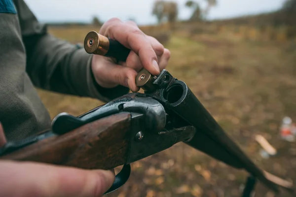 Hunter loading gun with bullets — Stock Photo