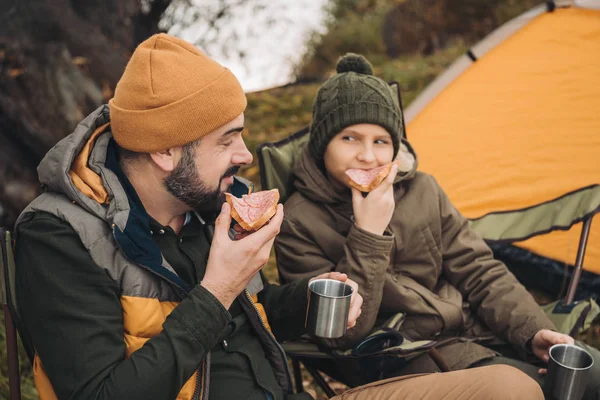 Padre e hijo bebiendo té y comiendo - foto de stock