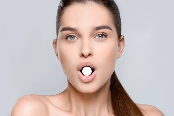 Woman holding white pill — Stock Photo