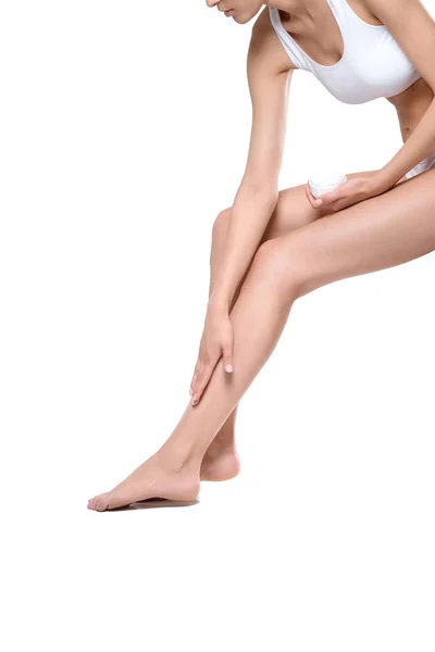 Femme appliquant la crème sur les jambes — Photo de stock