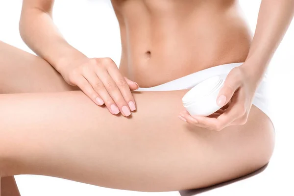 Femme appliquant la crème sur les jambes — Photo de stock