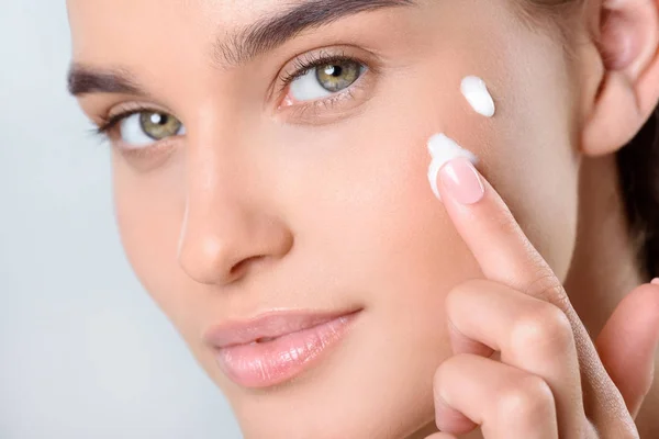 Woman applying face cream — Stock Photo