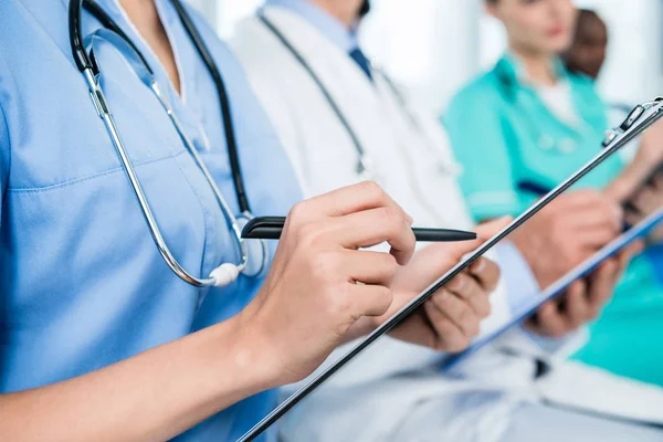 Nurse writing in clipboard — Stock Photo