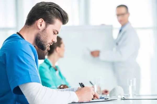 Médico escrevendo na área de transferência — Fotografia de Stock