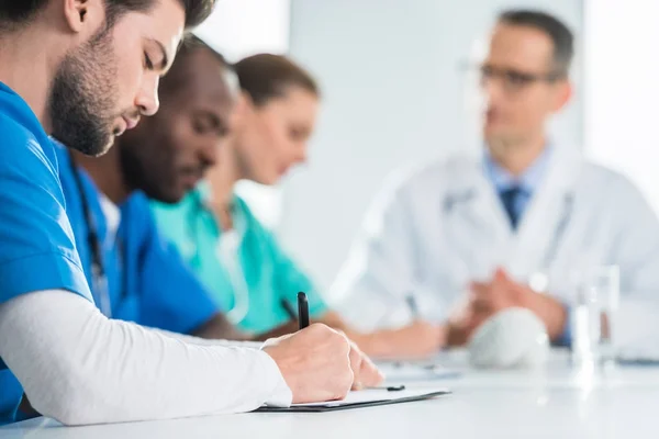 Doctor escribiendo en portapapeles - foto de stock