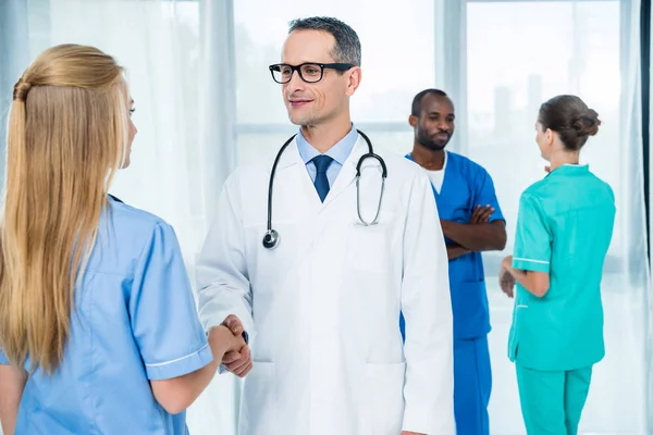 General practitioner shaking hand of nurse — Stock Photo