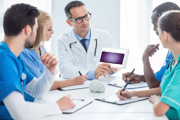 Врачи беседуют и смотрят на планшет — Stock Photo