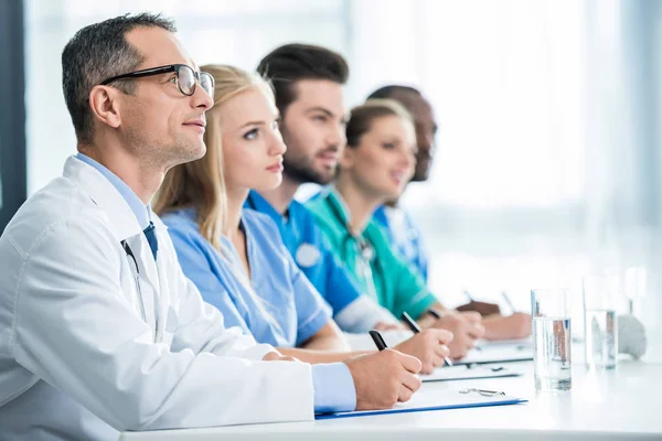 Ärzte sitzen mit am Tisch — Stockfoto