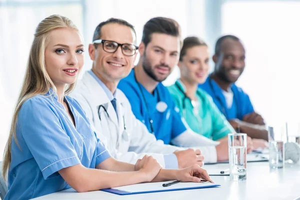 Médicos sentados a la mesa - foto de stock