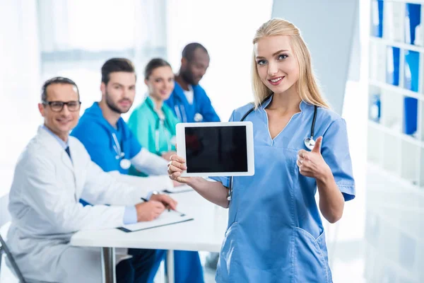 Nurse with tablet showing thumb up — Stock Photo