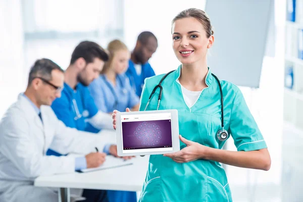 Enfermera joven sosteniendo tableta - foto de stock