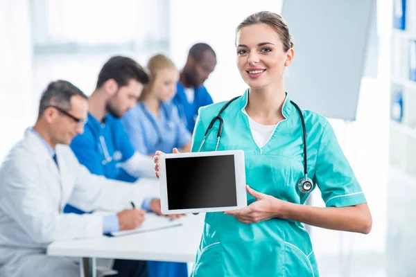 Enfermera joven sosteniendo tableta - foto de stock