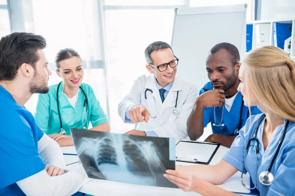 Team of doctors discussing x-ray scan — Stock Photo