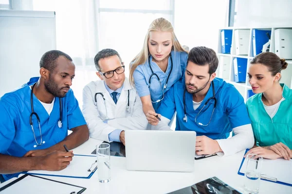 Médicos lluvia de ideas y el uso de la computadora portátil - foto de stock