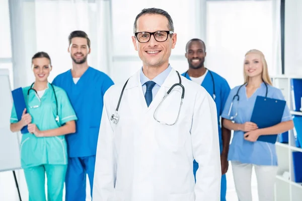 Mature doctor with colleagues — Stock Photo