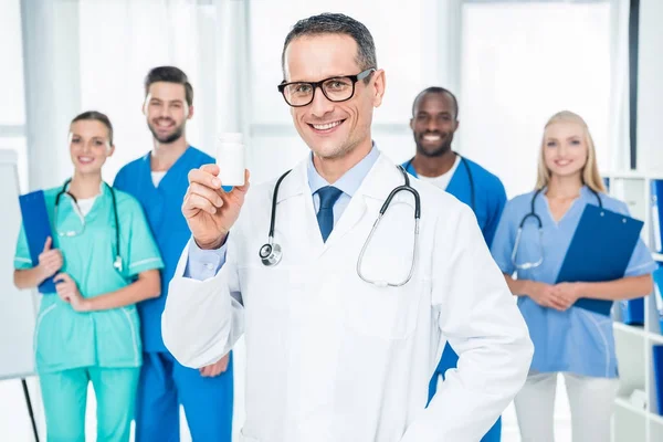 Doctor holding jar of pills — Stock Photo