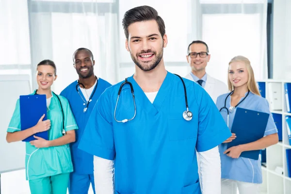 Joven médico con colegas - foto de stock