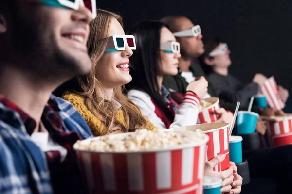 Giovani amici in bicchieri 3d con popcorn e soda guardando film nel cinema — Foto stock