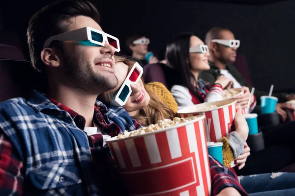 Jovens casais em óculos 3d com pipoca e refrigerante assistindo filme no cinema — Fotografia de Stock