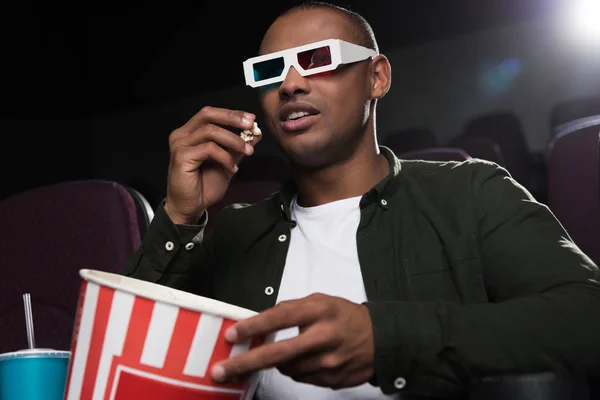 Afrikanisch-amerikanischer Mann in 3D-Brille isst Popcorn und schaut Film im Kino — Stockfoto