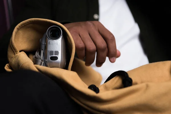 Cropped view of african american man with video camera pirating in cinema — Stock Photo