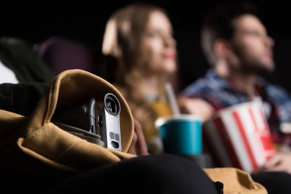 Selective focus of people with video camera pirating in cinema — Stock Photo