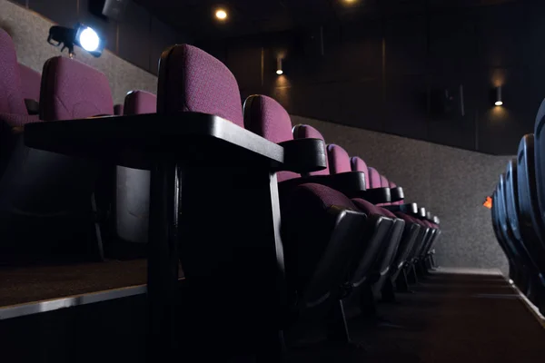 Sièges rouges dans le cinéma noir vide — Photo de stock