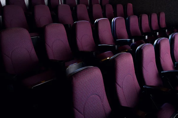 Red seats in empty dark movie theater — Stock Photo